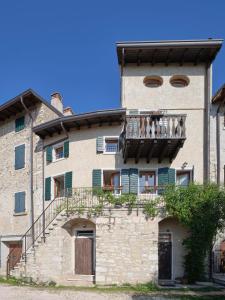 an old stone building with a balcony and stairs at La Casa di Mia - country house in Torri del Benaco