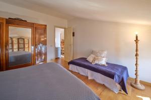 a bedroom with two beds and a mirror at La Casa di Mia - country house in Torri del Benaco