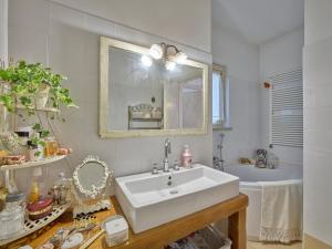 a white bathroom with a sink and a mirror at La Casa di Mia - country house in Torri del Benaco