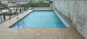 a large swimming pool on a building with a wooden floor at Piso Altos de Foz in Foz