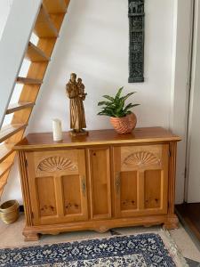 une armoire en bois avec une statue dessus dans une pièce dans l'établissement Ulrikesferienwohnung1, à Hombourg