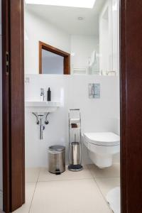 a white bathroom with a toilet and a sink at Victus Apartamenty, Apartament Ocean in Sopot