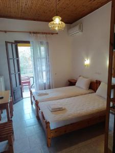 a bedroom with two beds in a room with a window at Elvira Apartments in Roda