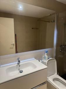 a bathroom with a sink and a toilet and a mirror at Euro 27 in Madrid