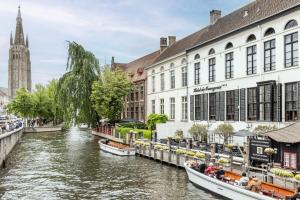 布鲁日Hotel De Orangerie by CW Hotel Collection - Small Luxury Hotels of the World的城市里一条有船只的河流