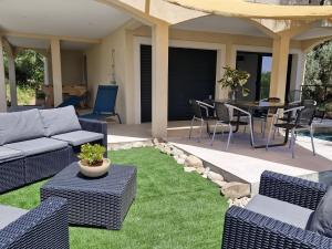 un patio con divano, tavolo e sedie. di Maison Rez-de-jardin 80 m de la plage a Serra di Ferro