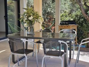 un tavolo da pranzo con due sedie e un piano in vetro di Maison Rez-de-jardin 80 m de la plage a Serra di Ferro Altre 3 foto
