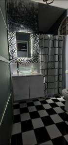 La salle de bains est pourvue d'un lavabo et d'un sol en damier. dans l'établissement departamento Saturno, à Guadalajara
