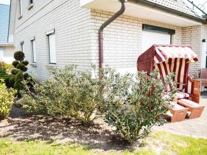 einen Garten mit einem Stuhl und Büschen vor einem Haus in der Unterkunft Appartements Stinteck WW45 in Stinteck