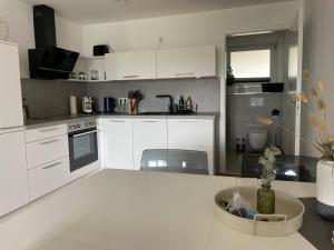 a kitchen with white cabinets and a white counter top at Modern apartment close Bodensee in Mühlingen