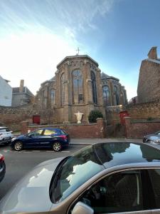 ein Auto, das vor einer Kirche parkt in der Unterkunft Studio calme proche de la gare in Amiens