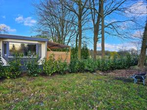 a small house in a yard with a fence at natuur huisje in Anloo