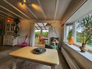 a living room with a table and a window at natuur huisje in Anloo