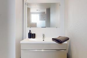 a white bathroom with a sink and a mirror at Charmant T2 Proche Centre - hôpital in Châteauroux