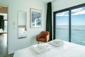 una camera da letto con un letto, una sedia e una finestra di GuestReady - Endless Ocean Views a Santa Cruz