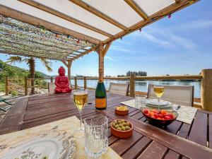 a table with a bottle of wine and a bowl of fruit at Eco lodge, vue exceptionnelle! in Duclair