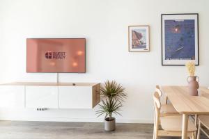 una sala da pranzo con TV su una parete bianca di GuestReady - Endless Ocean Views a Santa Cruz