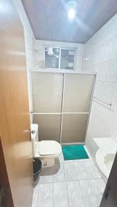 um pequeno banheiro com vaso sanitário e chuveiro em Suíte para moças! em Salvador