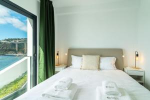 una camera da letto con un letto e una grande finestra di GuestReady - Endless Ocean Views a Santa Cruz Altre 32 foto