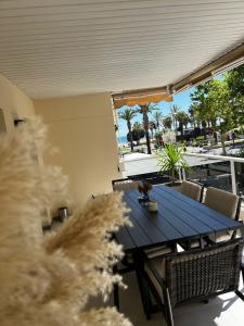 a blue table and chairs on a balcony with palm trees at Apartman Leoni 1 linea in Salou
