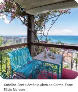 uma mesa na varanda com vista para o oceano em Suíte para moças! em Salvador