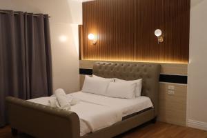 a bed with a stuffed animal on it in a room at H Mansion Hotel in Tandag