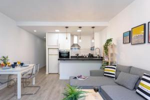 ein Wohnzimmer mit Couch und Küche in der Unterkunft Calle Agua Center&Parking&Woodland in Málaga