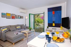ein Wohnzimmer mit einer Couch und einem Tisch mit Essen in der Unterkunft Calle Agua Center&Parking&Woodland in Málaga