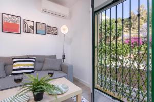 ein Wohnzimmer mit einem Sofa und einer Glastür in der Unterkunft Calle Agua Center&Parking&Woodland in Málaga