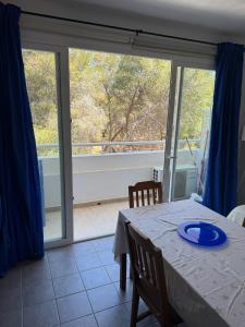 a dining room with a table and a large window at Edificio Es Pujols 10 ALTA TURISTICA in Es Pujols