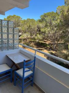 a table and chairs on a balcony with a view of trees at Edificio Es Pujols 10 ALTA TURISTICA in Es Pujols