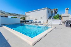 a swimming pool on the side of a house at Apartmani Sanja in Vir