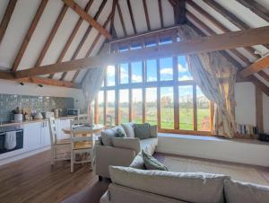 a living room with a couch and a large window at Kingfisher Barn in Abingdon