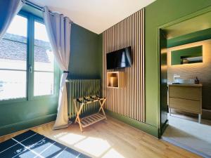a living room with green walls and a window at La Maison Le 14 - Un Jardin en Ville in Auxerre