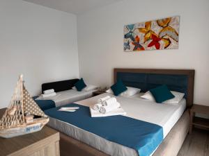 two beds in a room with a painting on the wall at Pensiunea CASID in Eforie Nord