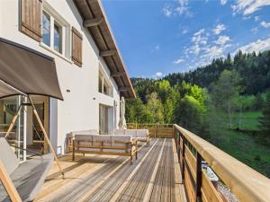 a deck with a couch and chairs on a building at Le Petit Paradis, Spa-Sauna and Gym in Gérardmer