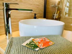 a bathroom with a sink and a table with a book at La Maison Le 14 - Un Jardin en Ville in Auxerre +38 photos