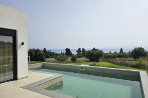 a swimming pool on the side of a house at Bellerive Villas in Kriopigi
