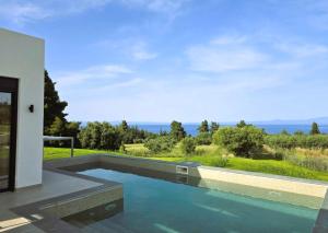 a swimming pool with a view of the ocean at Bellerive Villas in Kriopigi