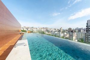 ein Schwimmbad auf dem Dach eines Gebäudes in der Unterkunft Moradia linda e moderna em um dos melhores bairros de Porto Alegre! in Auxiliadora