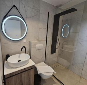 a bathroom with a sink and a shower with a mirror at Bellerive Villas in Kriopigi +51 photos