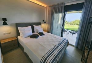 a bedroom with a large bed with a balcony at Bellerive Villas in Kriopigi
