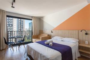 ein Hotelzimmer mit Bett und Balkon in der Unterkunft Moradia linda e moderna em um dos melhores bairros de Porto Alegre! in Auxiliadora + 110 Fotos