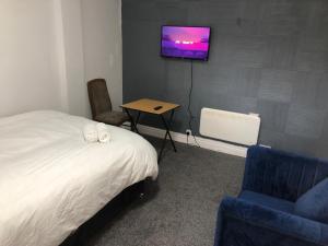 莫法特Marina Regency的一间卧室，墙上有一张床和一台电视