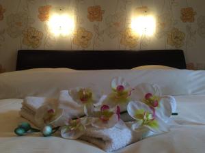 ヴィアンデンにあるBed & Breakfast du Châteauのベッドにタオルと花を飾った客室です。