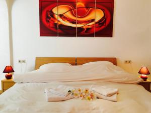 a bed with two towels and a painting on the wall at Bed & Breakfast du Château in Vianden