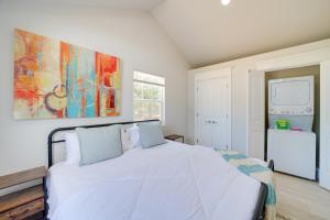 a bedroom with a white bed and a painting on the wall at Hike, Fish and Explore Cabin Near Eufala Lake! in Crowder