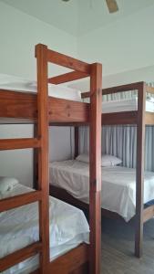 two bunk beds in a dorm room with white sheets at Descanso en Tortugas, Villas La Mar Monterrico in El Garitón +14 photos