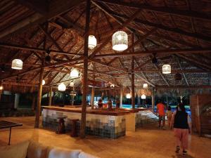 a bar in a building with people walking around it at Descanso en Tortugas, Villas La Mar Monterrico in El Garitón