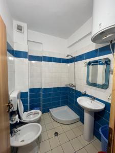 a blue and white bathroom with a toilet and a sink at Orikum RelaxHouse in Orikum +3 photos